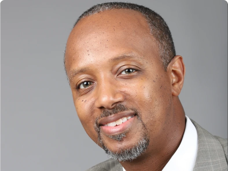 Smiling man in a grey suit.