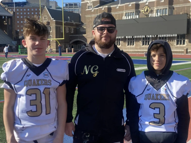 Three people in football uniforms on field.